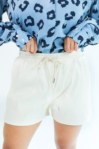 The Brooke Faux Leather Shorts In Cream